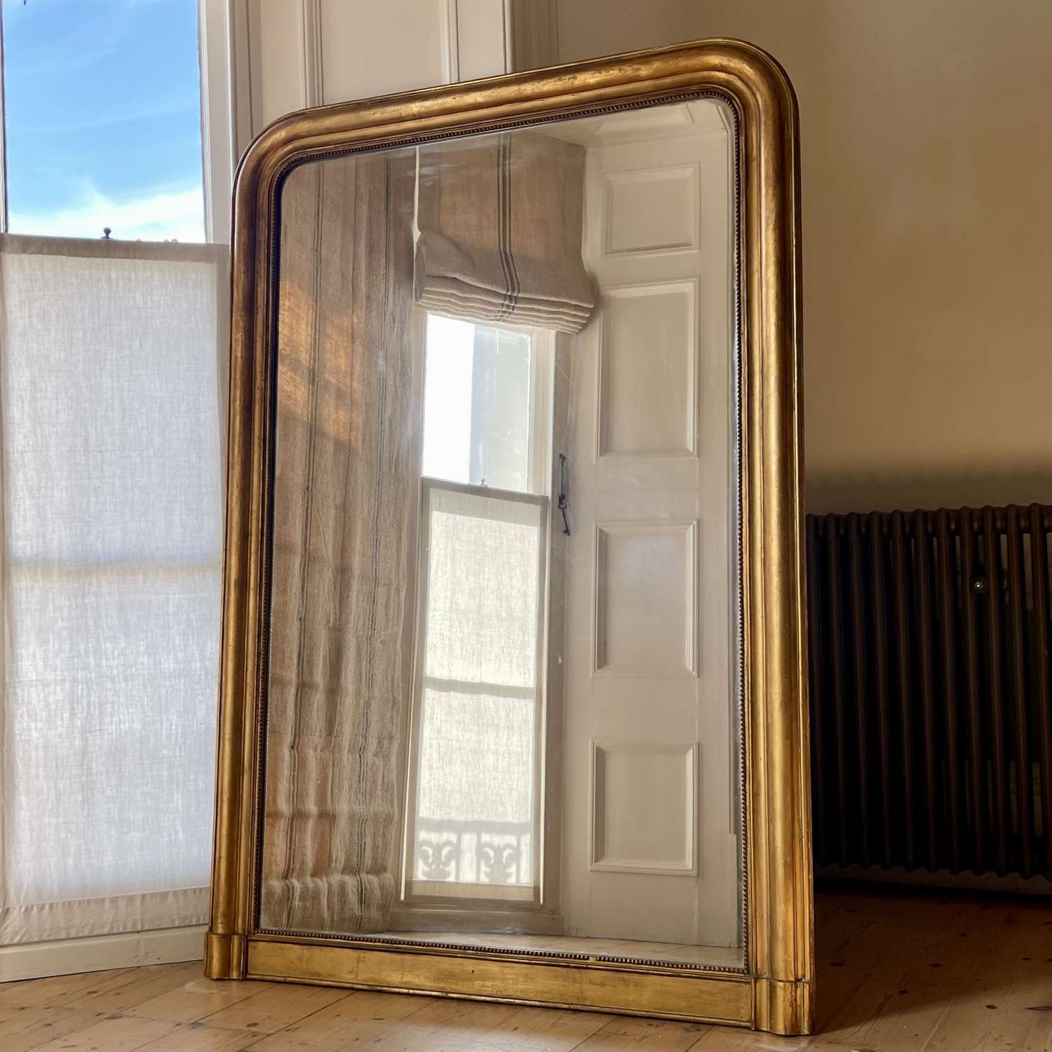 Large antique French gilt leaner mirror